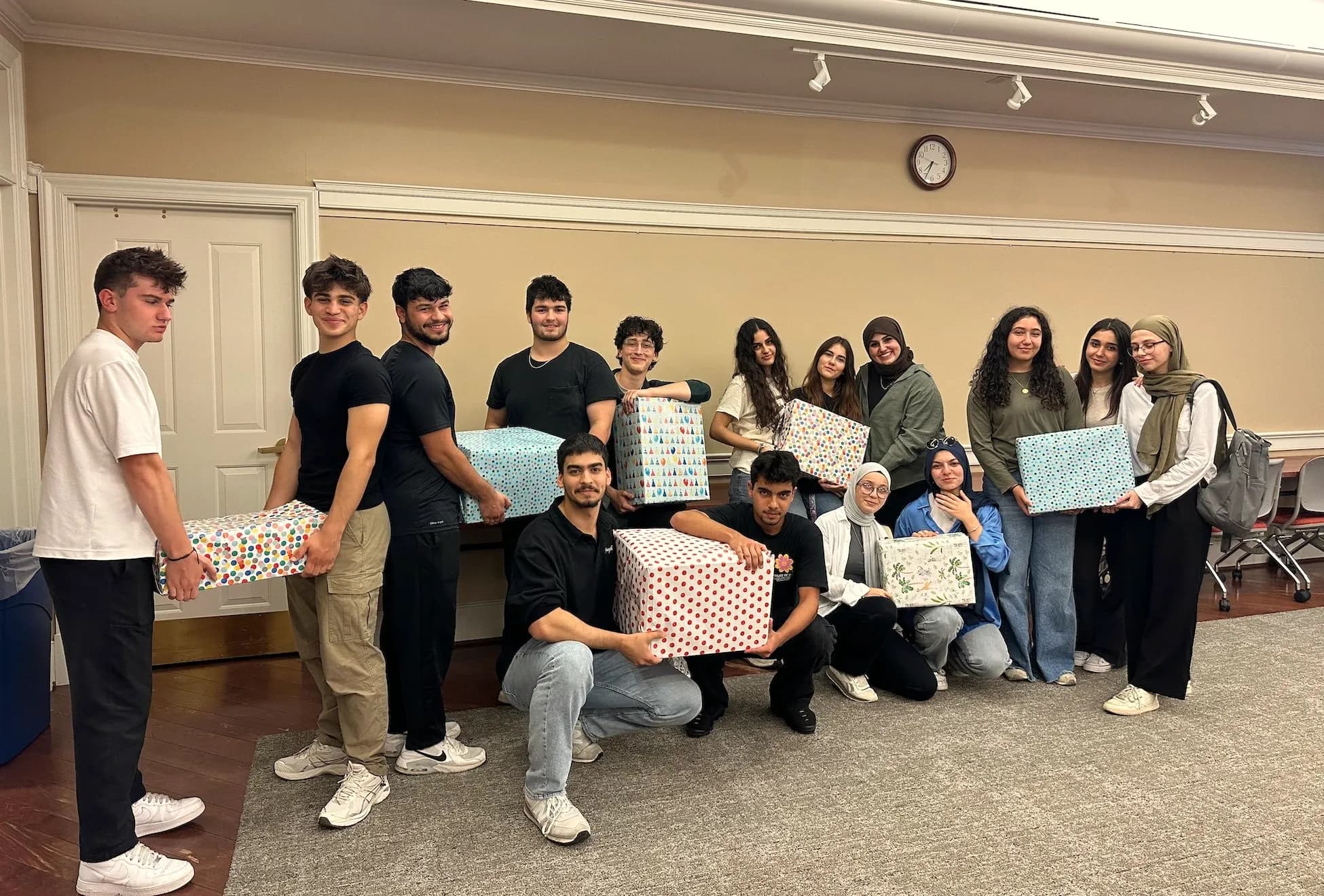 LeadUp volunteers hold the wrapped gift boxes they collected in a drive.