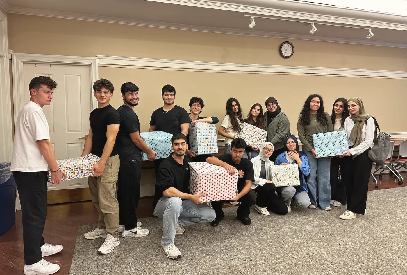 LeadUp volunteers holding the wrapped gift boxes they collected.